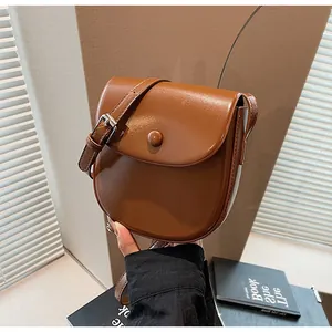 Detail einer braunen Vintage-Satteltasche mit glattem Lederfinish und verstellbarem Riemen
