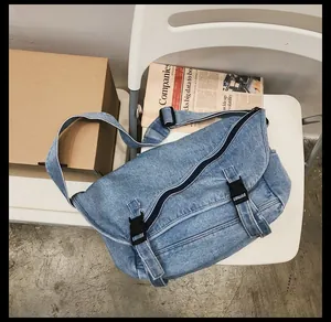 Dettaglio della borsa a tracolla in denim blu con fibbia in plastica e zip in metallo