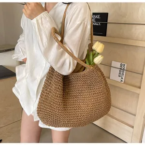Detail of dark brown woven straw tote bag with shoulder straps and fabric lining