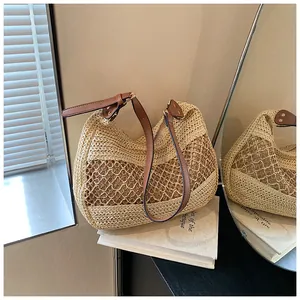 Close-up of cream woven beach bag featuring intricate hollow mesh and brown leather strap