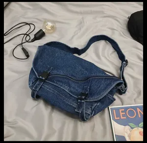 Dettaglio borsa a tracolla in denim blu con fibbia nera e trama del tessuto lavato denim