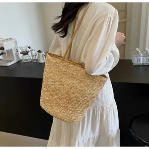 Side view of large straw tote bag with braided handles in a chic cafe setting
