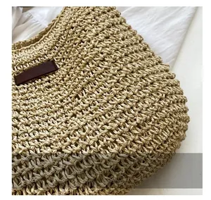Dettaglio macro della trama in rafia intrecciata beige con etichetta in pelle marrone