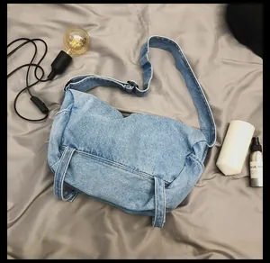 Vista dettagliata della borsa a tracolla in denim azzurro con cinghie regolabili
