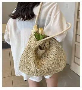 Detailed close-up of large straw tote bag featuring intricate hollow weave and natural texture