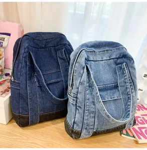 Close-up of denim tote bags in light and dark wash with side zipper pockets and stitching