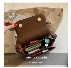 Detalle del bolso de cuero marrón con dos compartimentos y gran capacidad interna