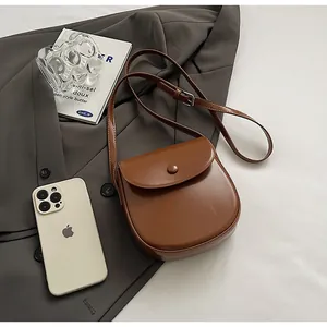 Detail einer braunen Satteltasche aus Leder mit verstellbarem Riemen und Metallschnalle