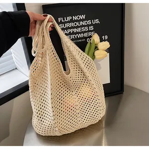 Detail view of beige hollow knit tote bag showing intricate crochet weave and diamond texture