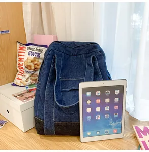 Detail of blue denim tote bag on a wooden table showing material texture and large capacity