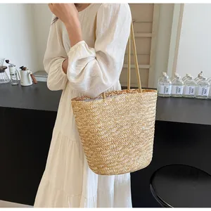 Detailed close-up of natural straw tote bag featuring fine woven patterns and linen lining
