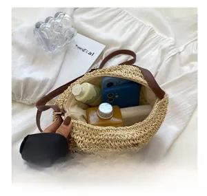 Dettaglio dell'ampia capacità interna della borsa da spiaggia in paglia con accessori