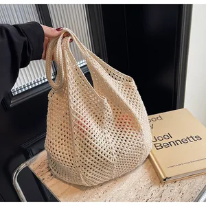Detail shot of a beige hollow knit tote bag showing the woven mesh texture and large capacity