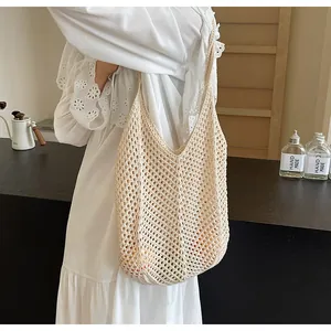 Close-up of beige crochet hollow-out tote bag with handmade woven mesh texture on shoulder