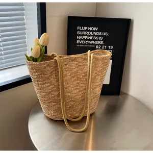 Detail of straw woven tote bag featuring soft fabric lining and khaki handles