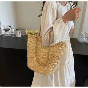 Detailed close-up of a large capacity hand-woven straw tote bag with long woven straps