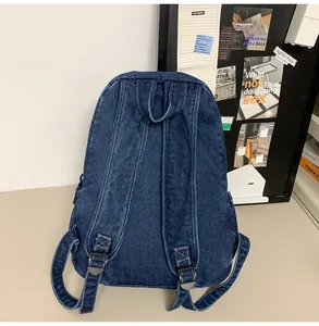 Detail van de achterkant van de donkerblauwe denim rugzak met brede verstelbare riemen