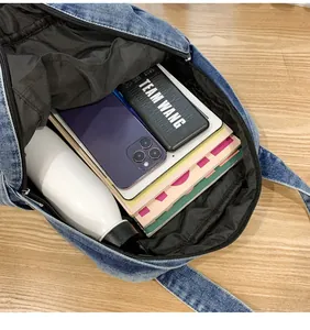 Spacious interior of blue denim tote bag showing capacity for books and tablet