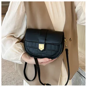 Detailed view of a vintage black saddle bag with crocodile texture and gold shield lock