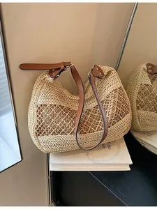 Handwoven straw shoulder bag with hollow mesh design and brown leather strap