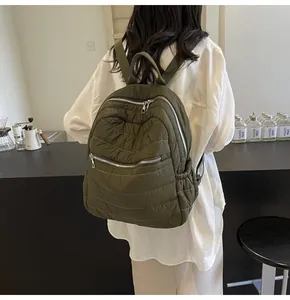 Dettaglio dello zaino trapuntato verde militare con cerniere metalliche e cuciture