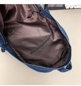 Detailopname van blauwe denim rugzak binnenzijde met bruine voering en ritszakje