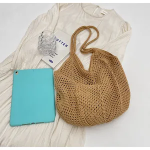 Close-up of handmade hollow knit tote bag showing intricate crochet mesh and wood tone texture