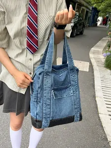 Denim blue large tote bag with black base, shown in casual outdoor lifestyle setting