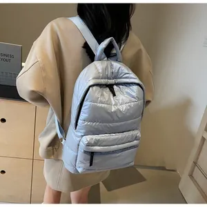 Detail of light blue quilted backpack showing puffer texture and adjustable straps