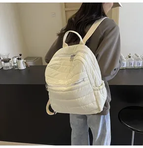 Dettaglio di uno zaino bianco trapuntato con doppia cerniera e design a sbuffo morbido