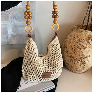 Detail of hand-woven beige tote with wooden beads and yellow rings on the handle