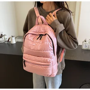Detail of pink quilted nylon puffer backpack with high-shine finish and padded top handle