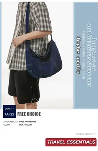 Detail view of deep blue denim crescent bag with wide shoulder strap and stitching