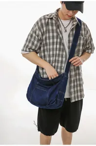 Detail of deep blue denim tote bag showing contrast stitching and functional side pockets