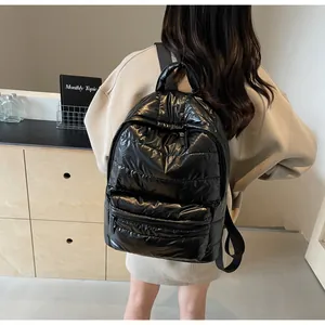 Rear view of black quilted backpack with glossy finish and adjustable shoulder straps