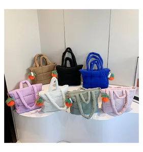 Detailed close-up of quilted puffy tote bags in multiple colors with carrot plush charms