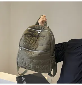 Dettaglio dello zaino trapuntato verde militare con cuciture a V e doppia zip