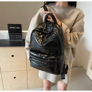 Detail of black quilted puffer backpack with shiny waterproof nylon and large front pocket