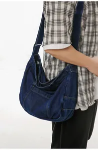 Detail view of large denim tote bag showing stitching and side pocket on blue fabric