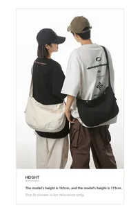 Detail van grote zwarte en witte canvas crossbodytassen gedragen door modellen