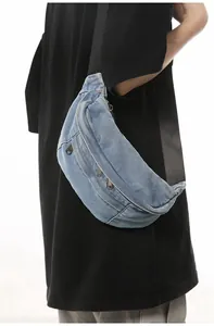 Close-up of light blue washed denim fanny pack with multi-zipper pockets and black strap