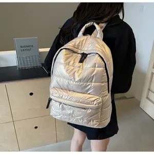 Detailed close-up of champagne gold quilted backpack featuring sleek metallic texture and zippers