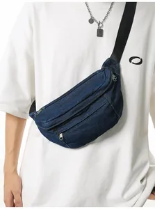 Close-up of deep blue denim crossbody bag featuring multiple zippers and woven strap