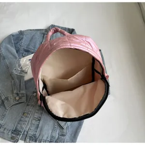 Detail view of pink quilted backpack showing spacious interior main pocket and lining