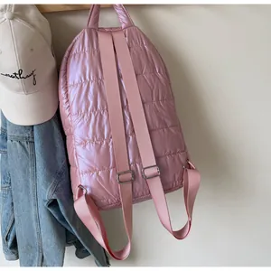 Detail of pink quilted backpack showing glossy puffer material and adjustable straps