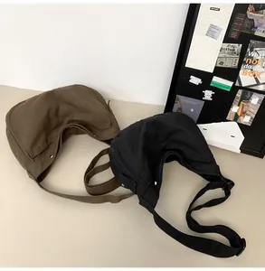 Detailansicht der großen Canvas-Halbmond-Umhängetaschen in Schwarz und Dunkel-Khaki