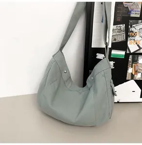 Detailansicht der salbeigrünen Canvas-Umhängetasche mit Seitentasche und breitem Schultergurt
