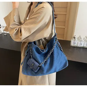 Détail du grand sac cabas en jean bleu foncé avec chaîne argentée et pochette
