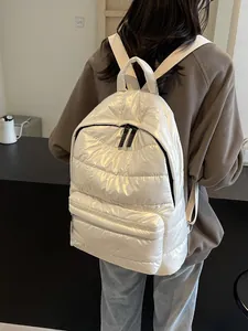 Quilted white puffer backpack with metallic finish featuring large capacity and padded nylon