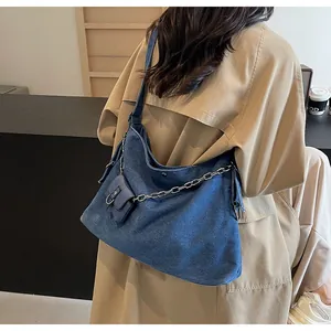 Detail of blue denim tote bag with silver metal chain and detachable coin purse pouch